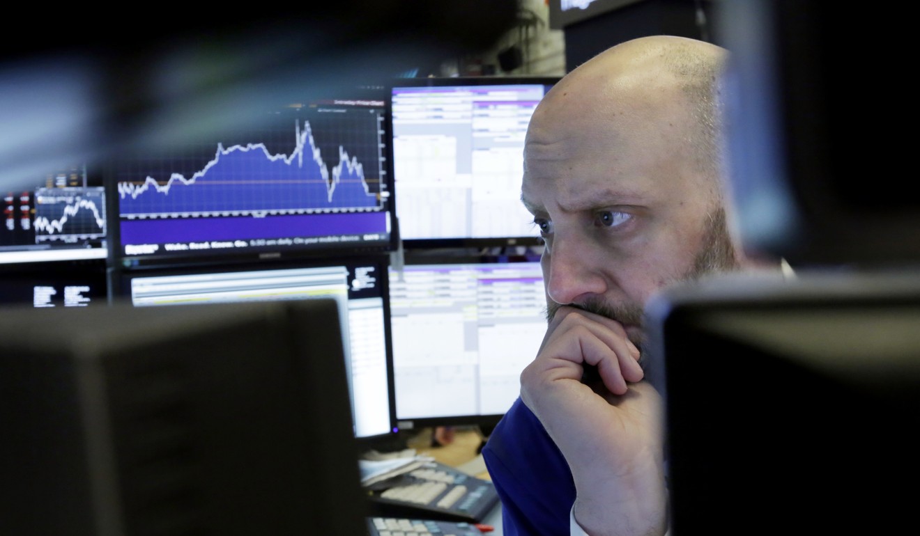 Trader Meric Greenbaum is framed by his monitors as he works on the floor of the New York Stock Exchange on Thursday. Photo: AP