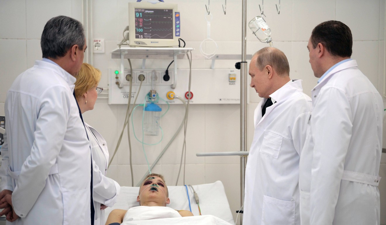 Russian President Vladimir Putin visits an injured fire victim in hospital. Photo: EPA