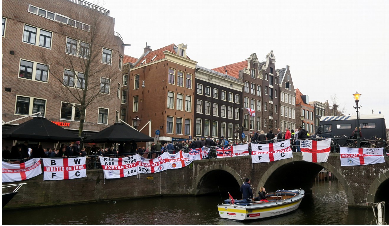 England flags line the railings of a canal in Amsterdam. Photo: Reuters