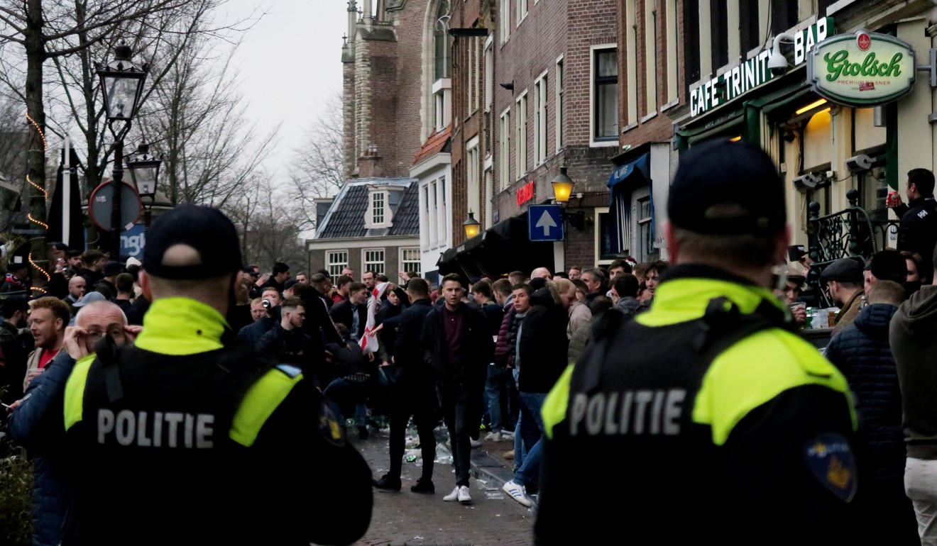 Police look on at England fans outside a bar in Amsterdam. Photo: Reuters