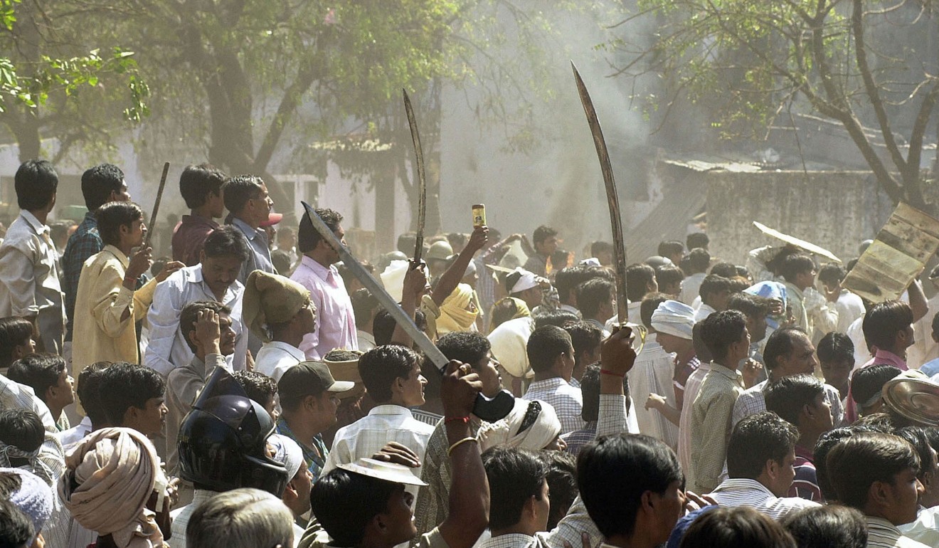 A Hindu mob waves swords at an opposing Muslim mob during communal riots in Ahmedabad in 2002. File photo