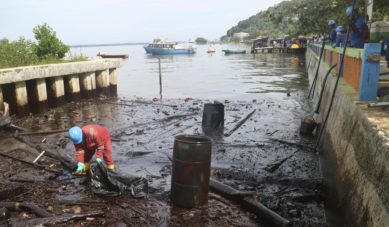 A worker cleans up oil that inundated the coastline in Balikpapan. Photo: AP