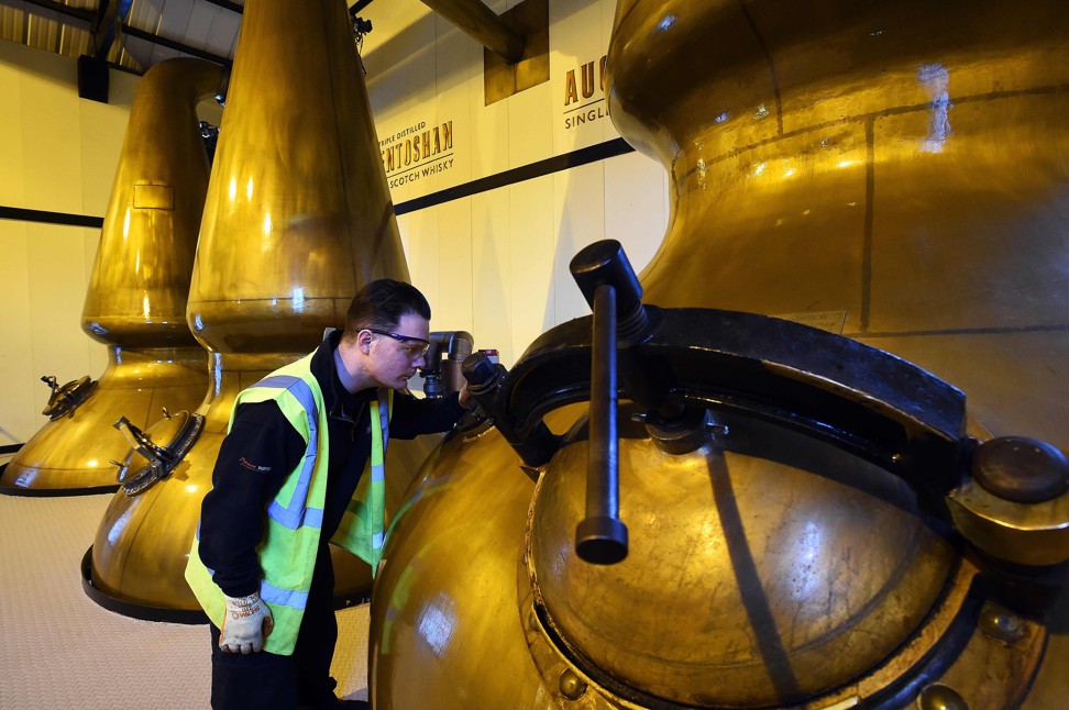 Employee Colin O'Hara checks the pot stills in the Still House at the Auchentoshan Distillery near Glasgow, Scotland. Photo: AFP