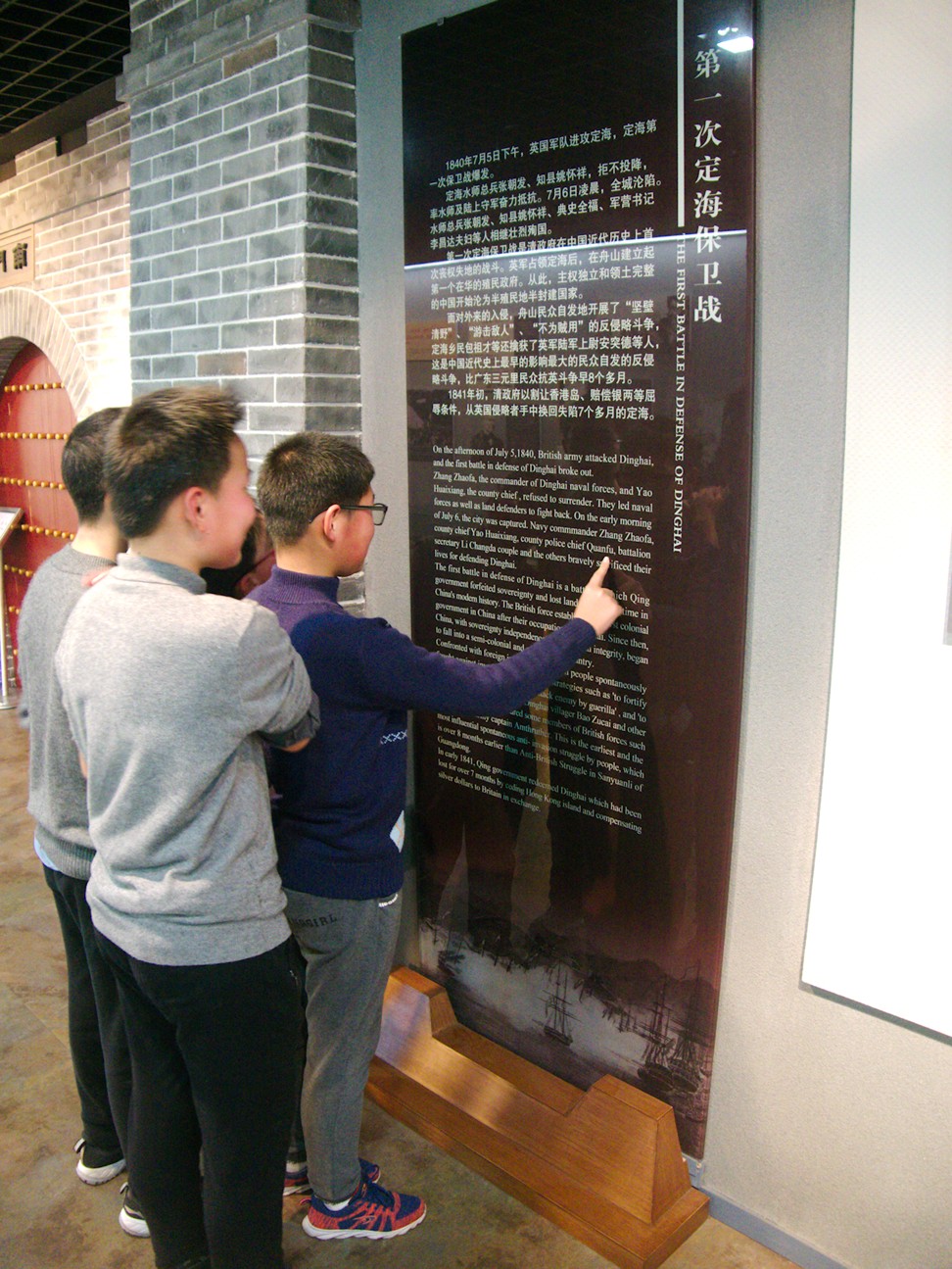 Local schoolboys read about Zhoushan’s bloody history at the Opium War Ruins Museum. Photo: Stuart Heaver