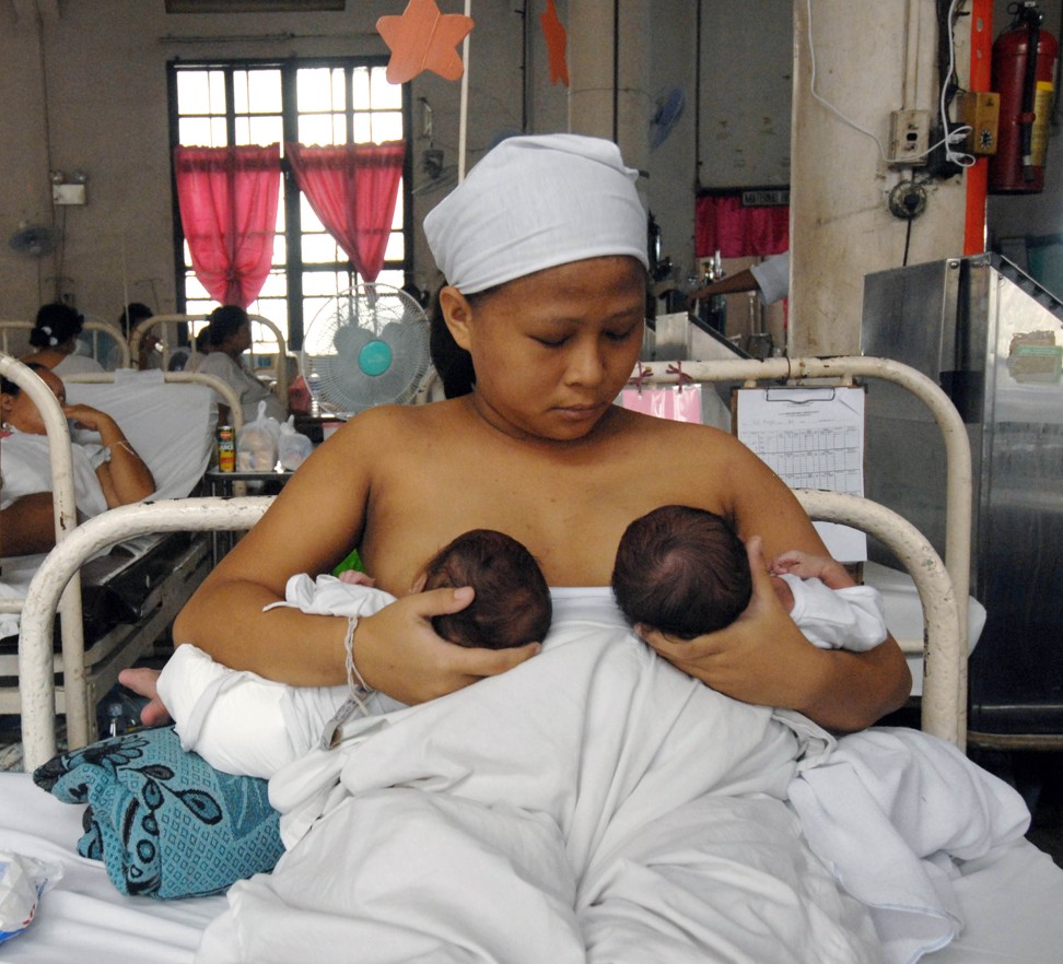 A mother breastfeeds her 10-day old twin baby girls at the Jose Fabella Memorial Hospital in Manila. Milk formula companies have been accused of offering incentives to doctors, midwives and other health professionals in deprived areas of the Philippines to push milk formula over breastfeeding. Photo: AFP