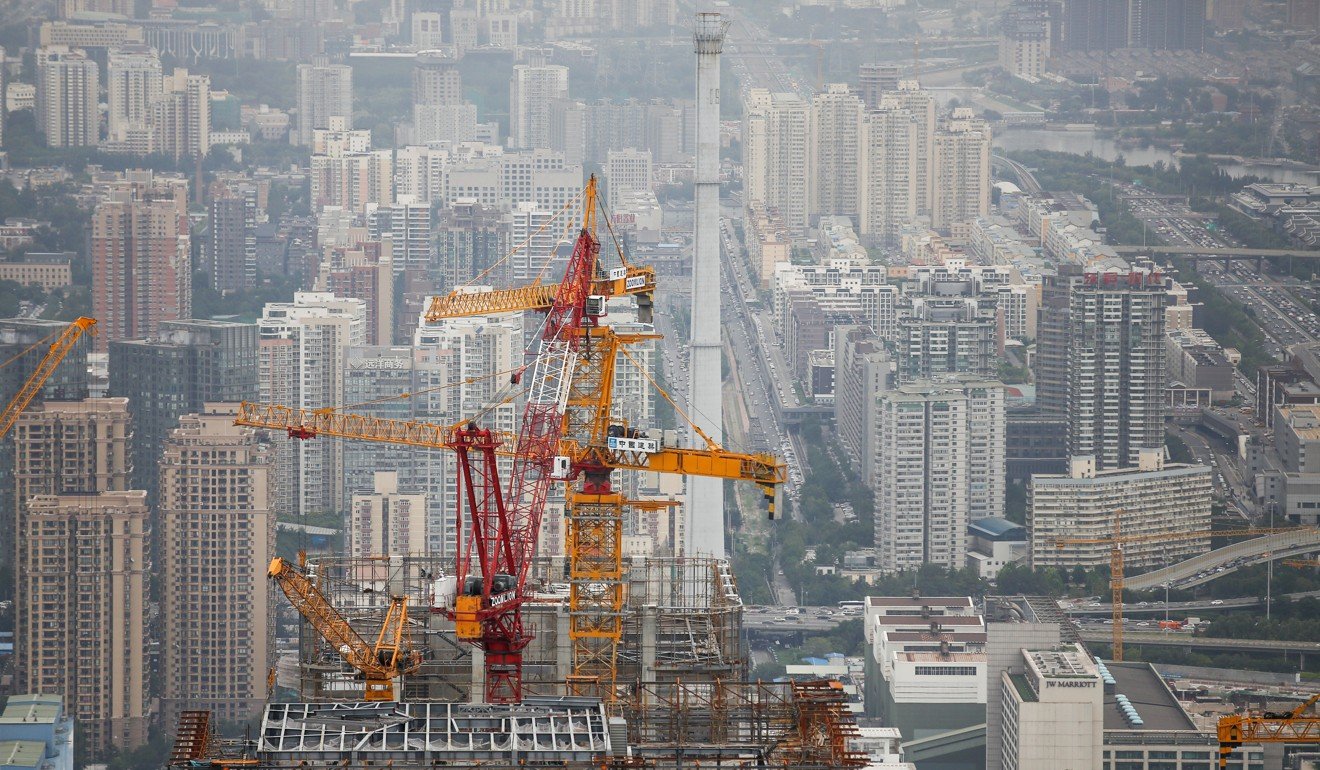 Constructions cranes as seen on top of a skyscraper underway in Beijing. Photo: Reuters