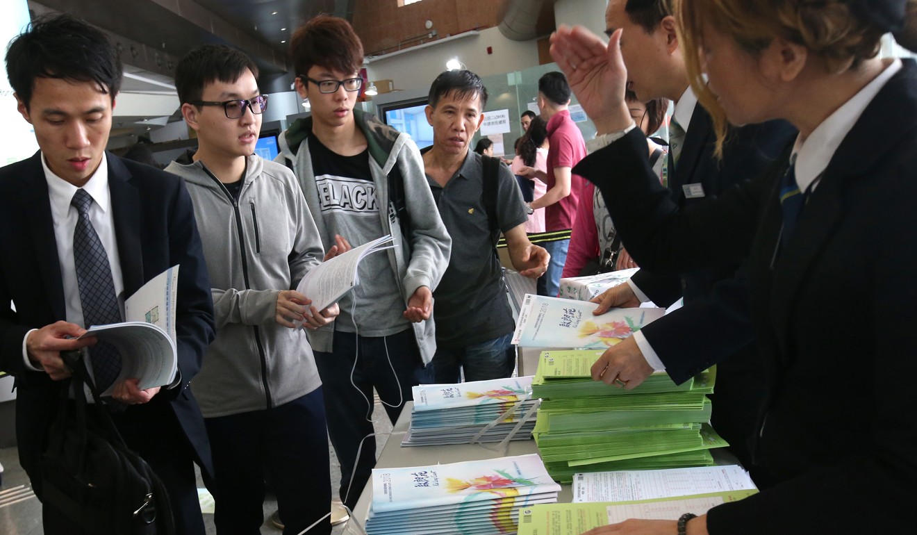 Prospective buyers take application forms for the sale of Home Ownership Scheme flats in Kai Tak, on March 29. The flats are part of the 4,400 subsidised units available for sale this year. Photo: David Wong