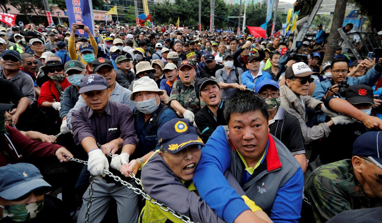 Protesters try to pull down gates at the parliament building in Taipei. Photo: Reuters