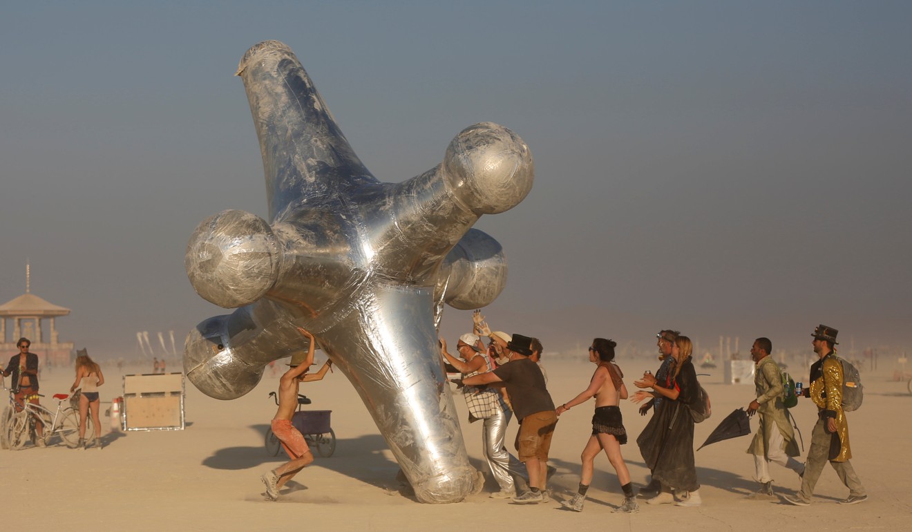 Participants push the art piece ‘The Jack’ along the playa at the 2017 festival. Photo: Reuters