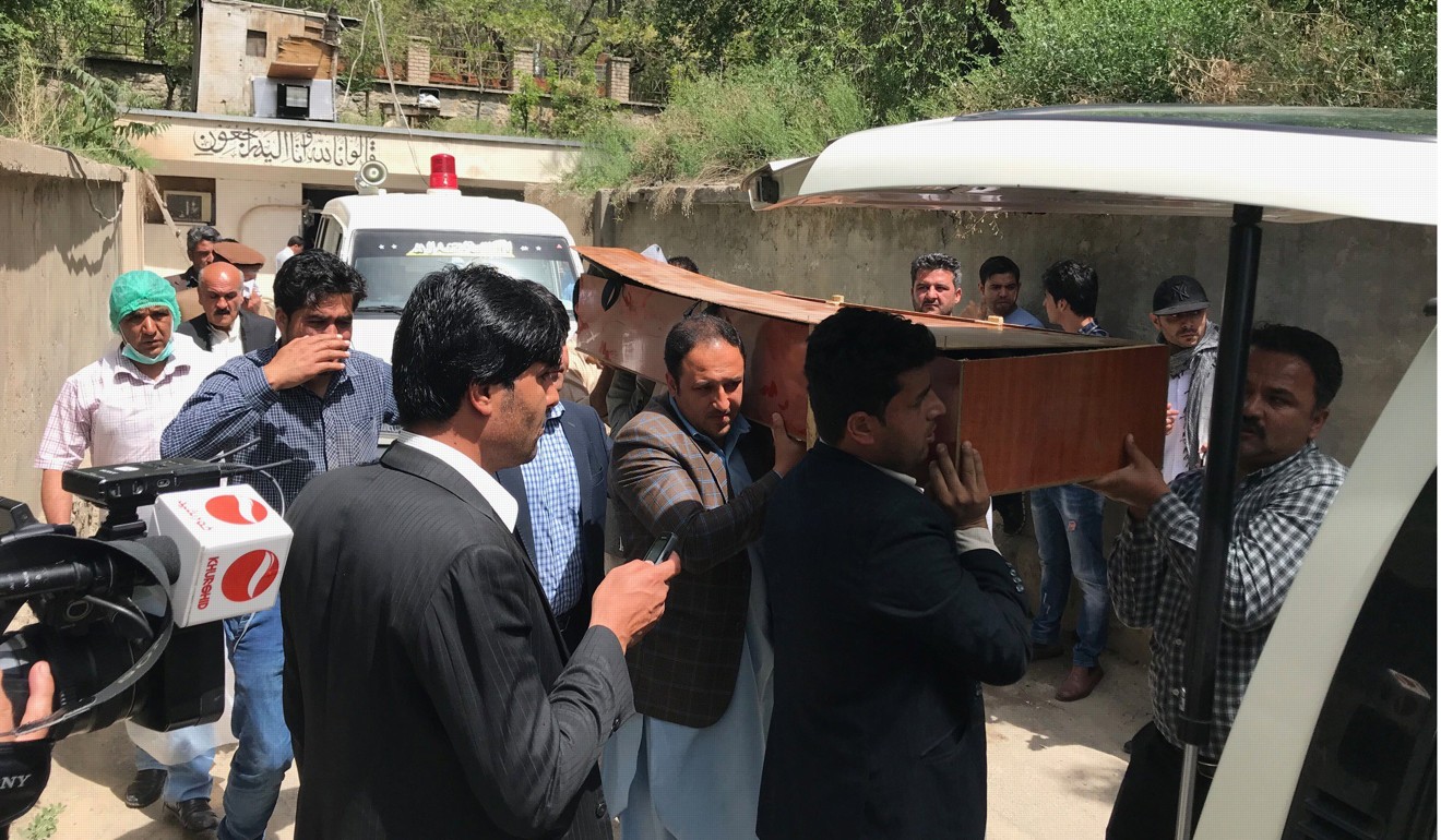 People move the body of an Afghan journalist who was killed in the twin bomb blasts. Photo: EPA