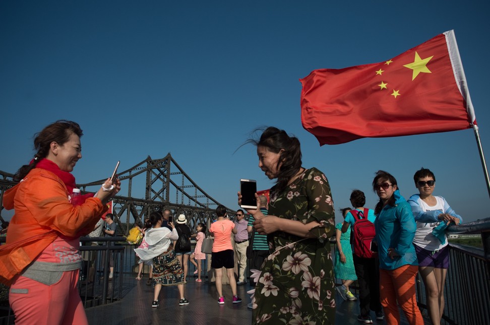 Tourists take pictures near the Friendship Bridge that links the North Korean town of Sinuiju to the Chinese city of Dandong. South Korean official Enna Park said Beijing has played a key role in getting Pyongyang to the negotiating table. Photo: AFP