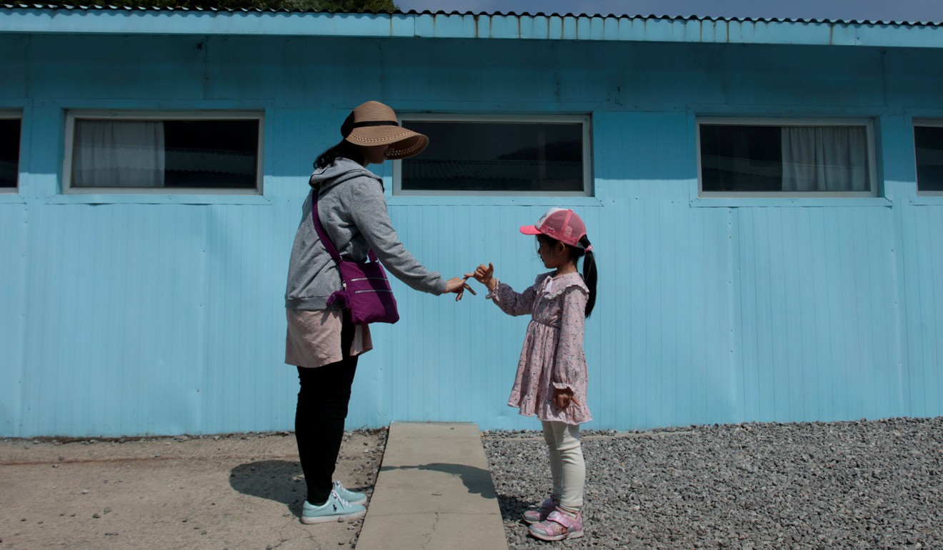 A woman and her daughter mimic the handshake between North Korean leader Kim Jong-un and South Korean President Moon Jae-in. Photo: Reuters