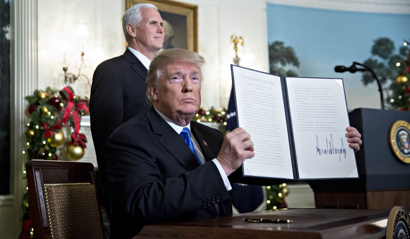 Trump holds up a proclamation in December after formally declaring Jerusalem to be Israel’s capital. Photo: Bloomberg