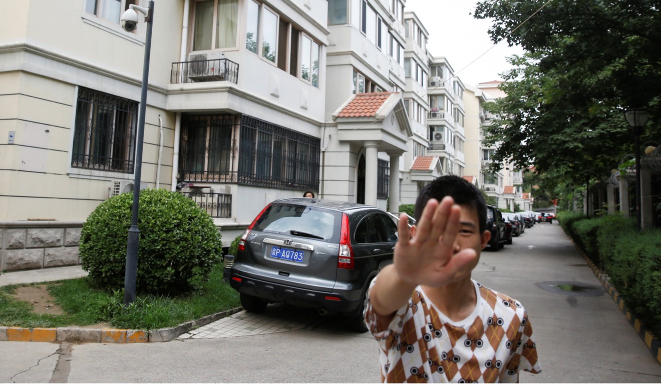 A plain clothes security officer attempts to stop a photographer taking pictures of Liu Xia’s home in Beijing in July. Photo: Reuters