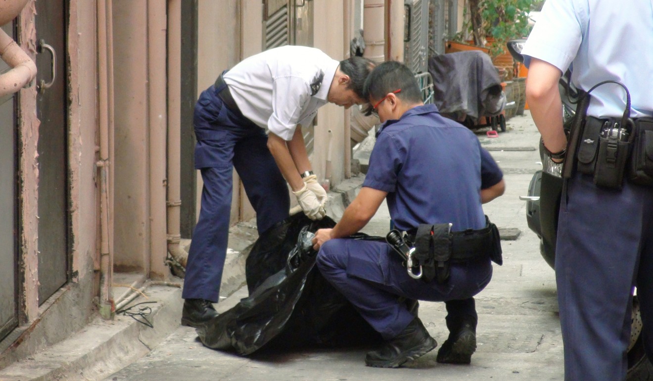 The police clean up the remains of a dog that was thrown off the roof of a building in Cheung Sha Wan. Photo: Handout