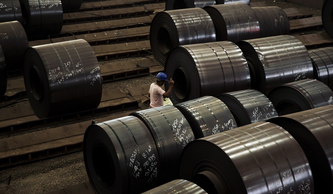 A worker walks past coils of rolled steel at the Jindal Stainless Ltd. factory in Hisar, India, on May 15. Photo: Bloomberg