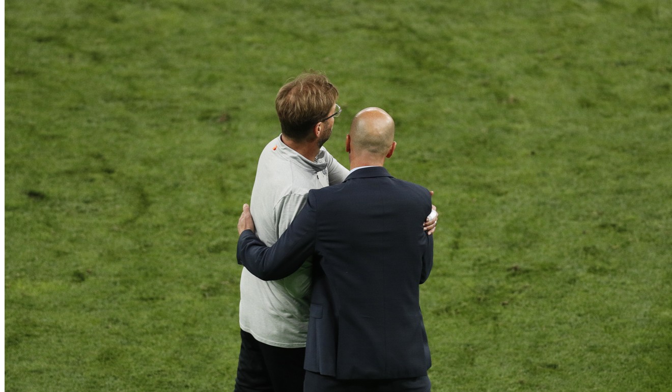 Liverpool manager Jurgen Klopp is embraced by Real Madrid head coach Zinedine Zidane at the final whistle. Photo: EPA