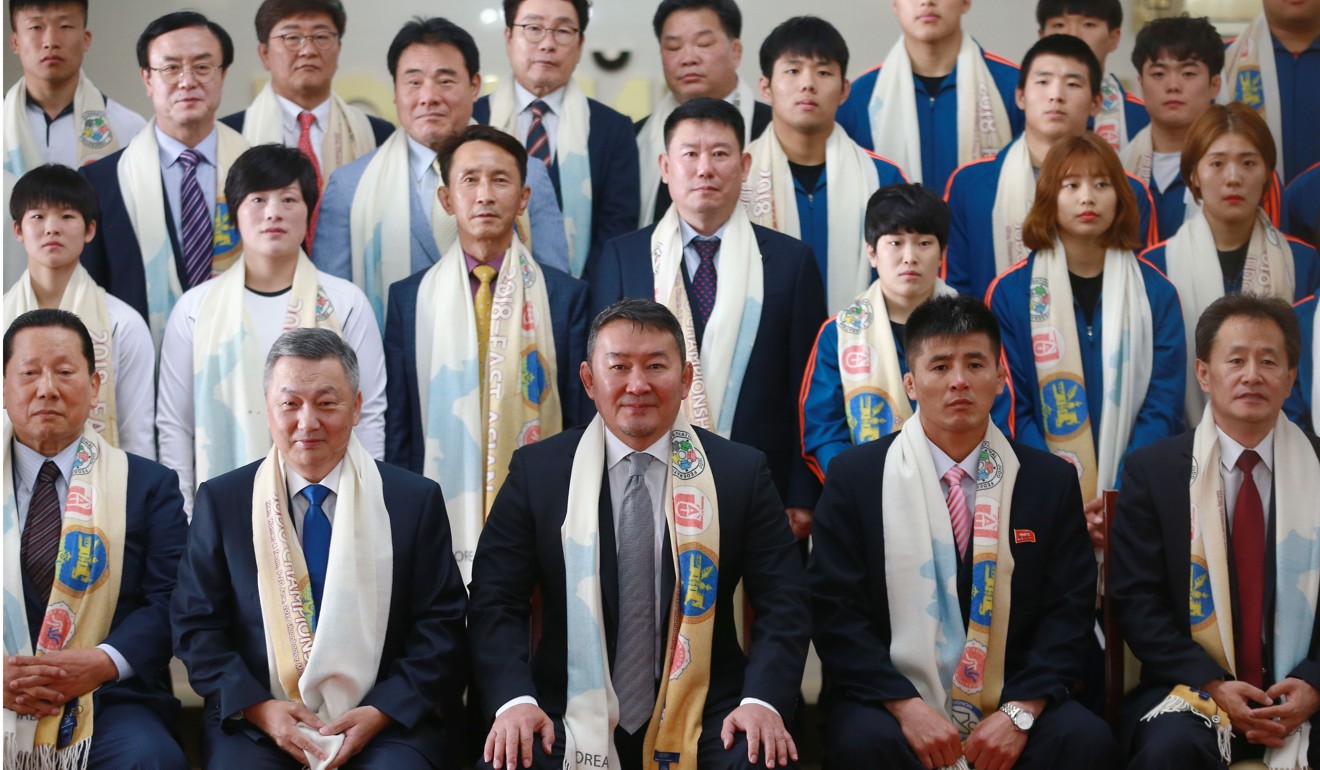 Mongolia president Khaltmaa Battulga (front centre) takes pictures with Zandaakhuugiin Enkhbold (front second left), chief of staff of the president’s office of Mongolia and head of the organising committee of the East-Asian Judo Championships, and Wong Kyong Il (front second right), coach of the North Korean judo team. Photo: AFP