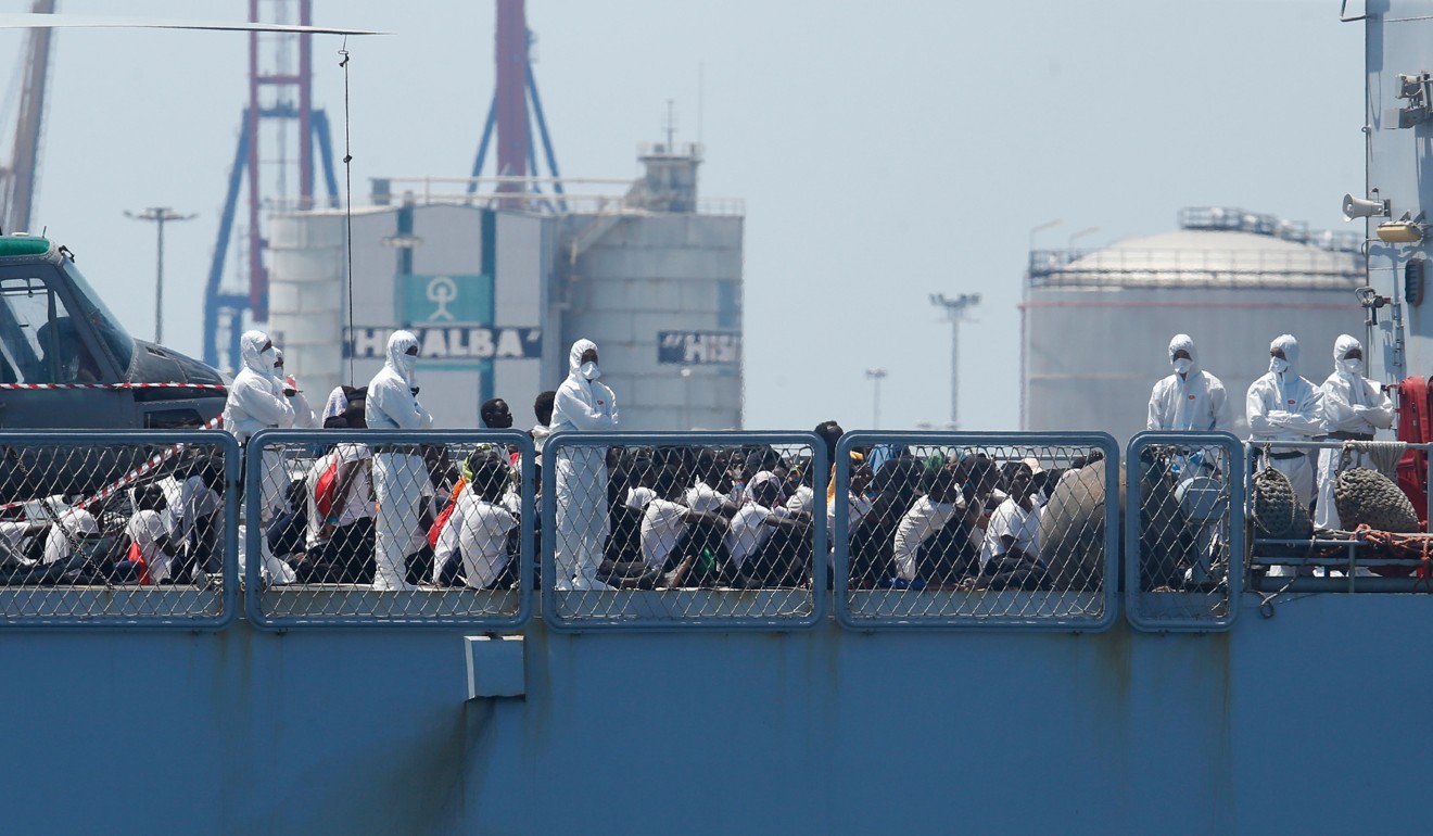 Migrants sit on the deck of the Italian navy ship Orione at the port of Valencia. Photo: AFP