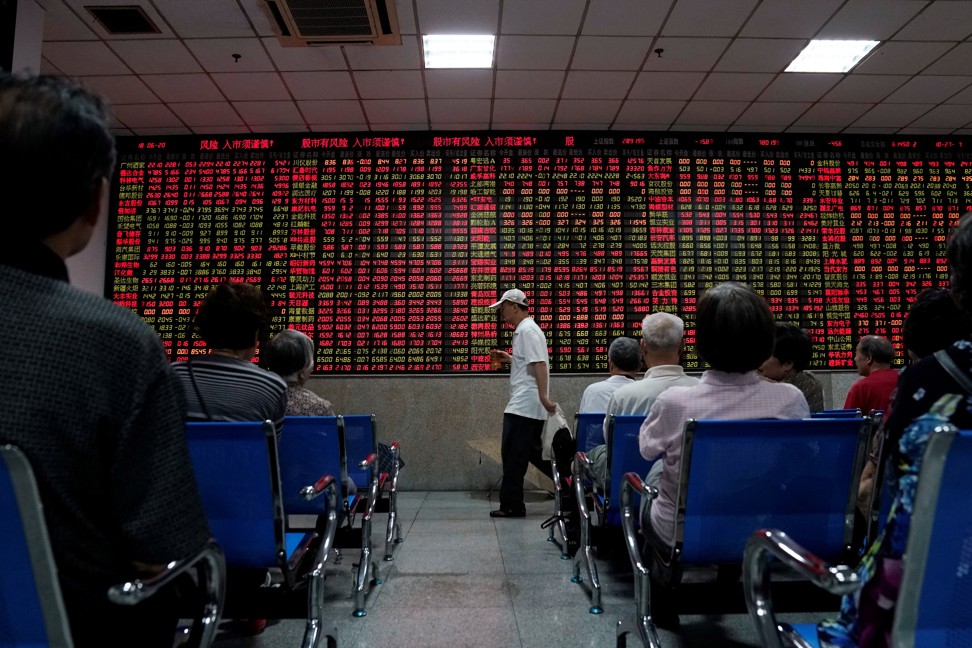 Investors look at an electronic board showing stock information at a brokerage house in Shanghai, China on Wednesday. Photo: Reuters