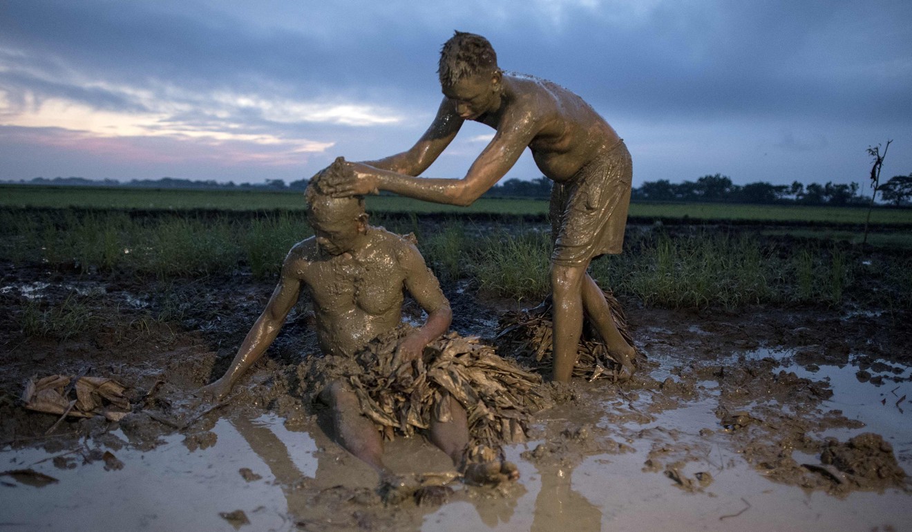 Devotees cover themselves with mud. Photo: AFP
