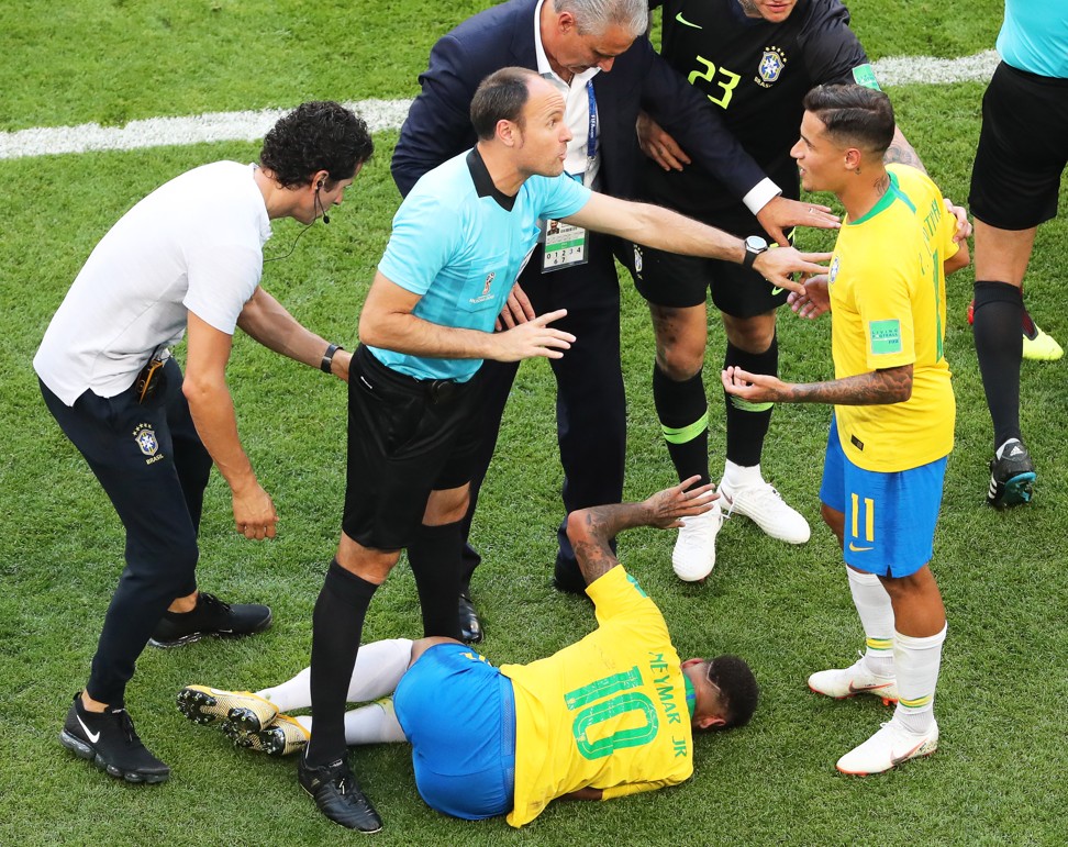 Neymar lies on the ground as Philippe Coutinho comes over. Photo: EPA