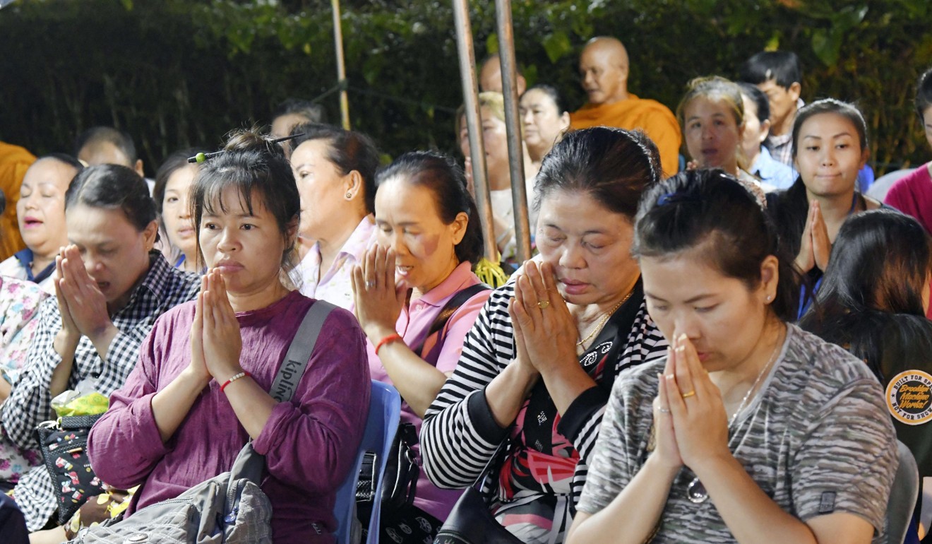 Women pray near the cave complex on Thursday. Photo: Kyodo