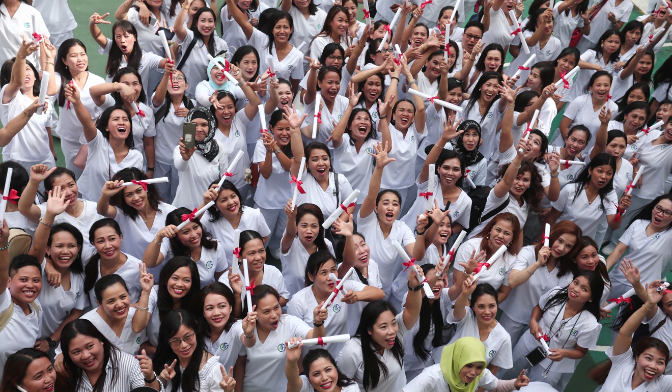 More than 200 foreign domestic workers, who graduated from a course on elderly care, celebrate in Kennedy Town. The number of English-speakers in Hong Kong has not declined since the British handover, thanks largely to the presence of domestic helpers. Photo: Jonathan Wong