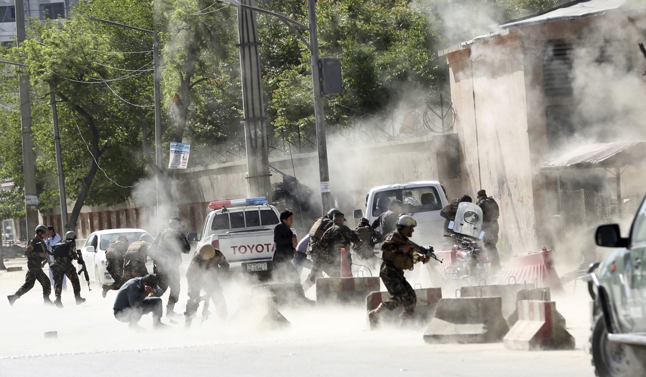 Security forces run from the site of a suicide attack in Kabul on April 30, 2018. Photo: AP