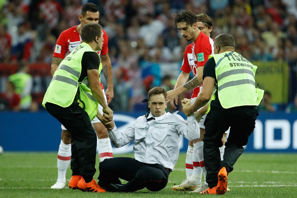 Stewards remove pitch invaders during the Russia 2018 World Cup final football match. Photo: AFP