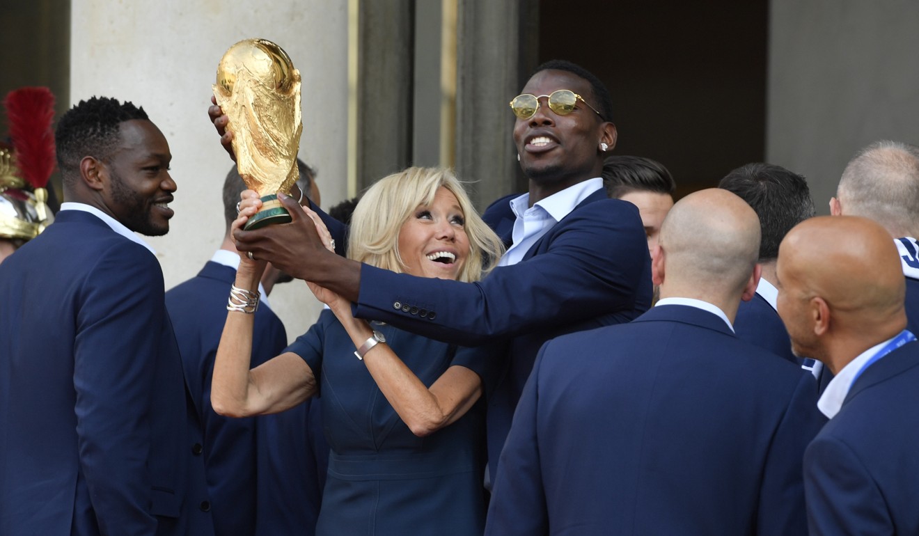 Paul Pogba and Brigitte Macron play around with the World Cup trophy. Photo: EPA