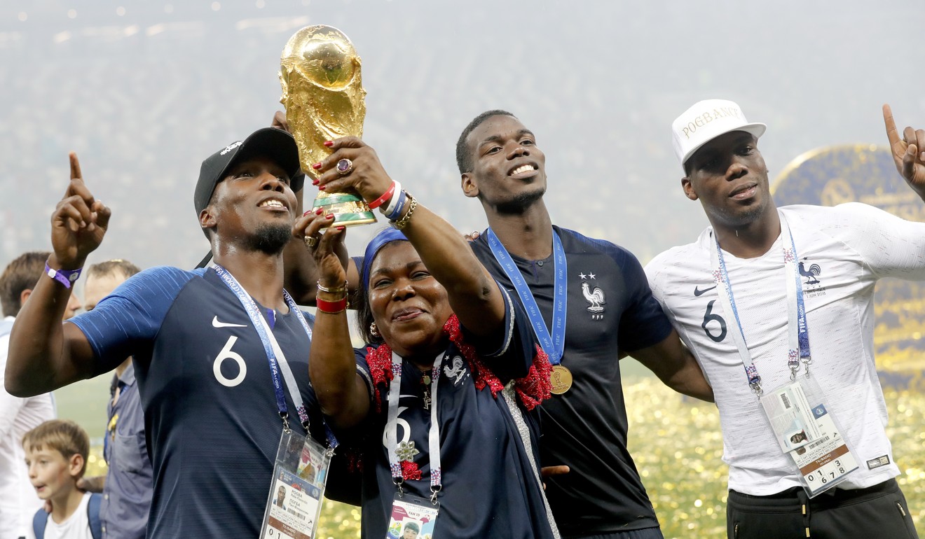 Paul Pogba and his brothers Florentin (left), Mathias (right) and their mother Yeo – who emigrated to France from Guinea – celebrate with the World Cup trophy. Photo: EPA