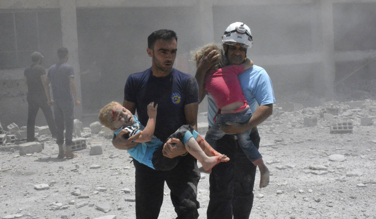 In this June 14, 2017, file photo, provided by the Syrian Civil Defence group known as the White Helmets, workers carryi children after airstrikes hit a school in the southern Daraa province of Syria. Photo: AP