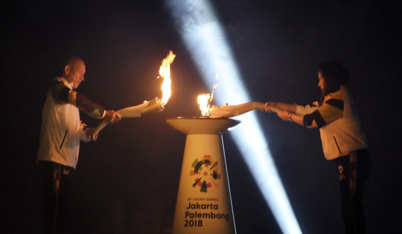 A flame received from India is merged with the sacred Javanese Mrapen eternal flame during a ceremony at Prambanan, a ninth-century Hindu temple complex in Central Java to begin the relay of the Asian Games torch. Photo: Kyodo