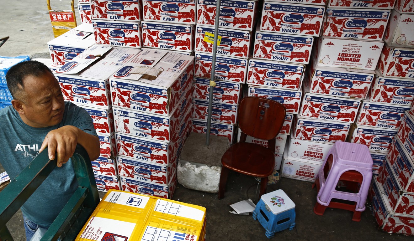 A man waits for the goods to be loaded on his tricycle at a dealer selling imported seafoods at the Jingshen seafood market in Beijing. Photo: AP