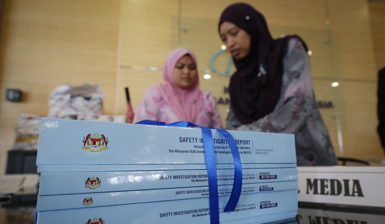 Staff arrange copies of the final investigation report on missing flight MH370 in Putrajaya, on Monday, July 30, 2018. Photo: AP