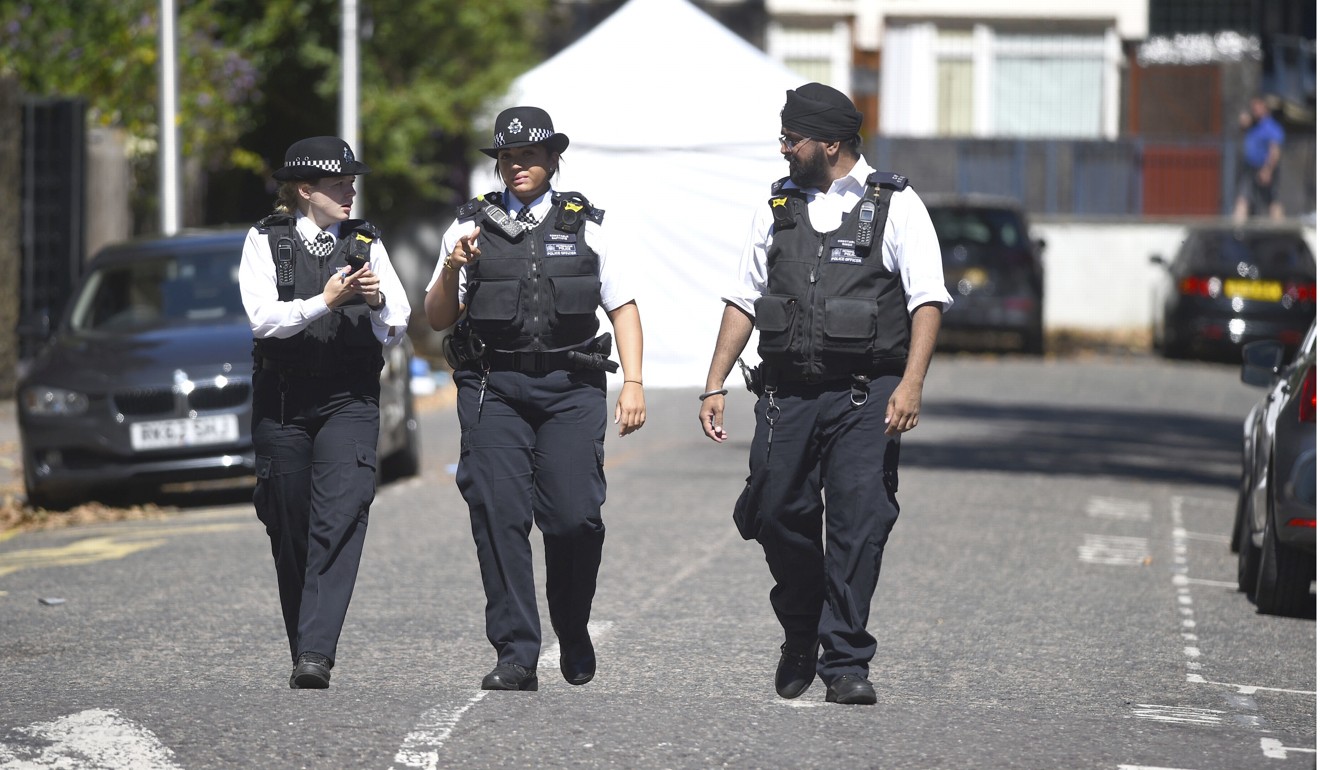Police officers near the scene of the killing in Camberwell, London. Photo: AP