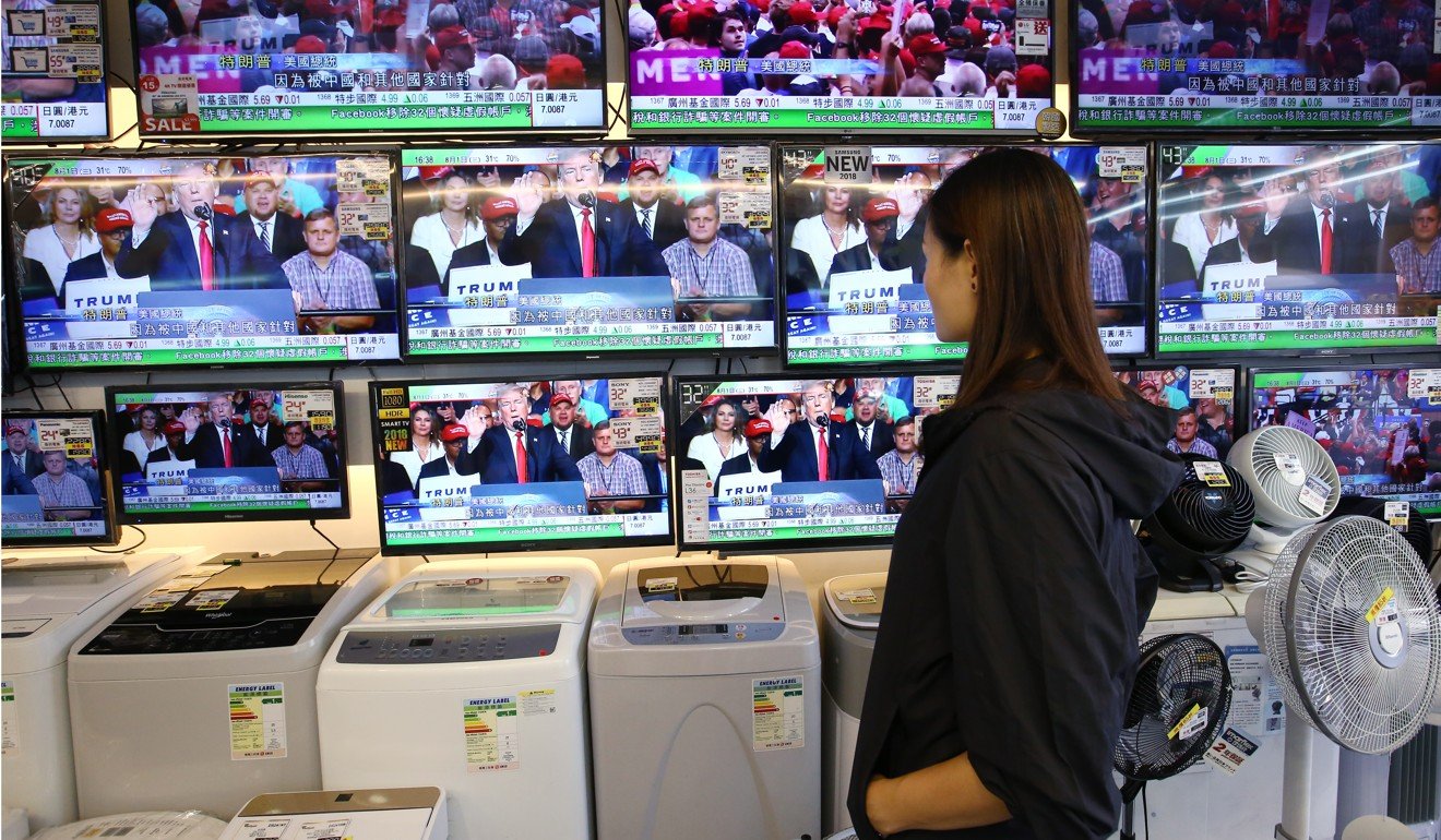 A woman looks at TV sets on display at a home appliance store in Kowloon City. Photo: Edmond So
