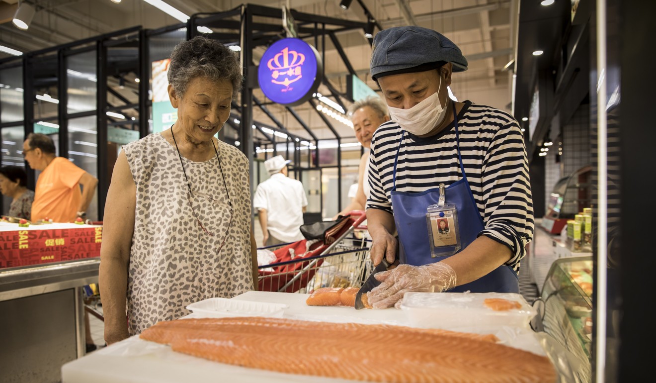 An employee prepares portions of salmon fillet inside a Vanguard hypermarket, in Shanghai, China. Photo: Bloomberg