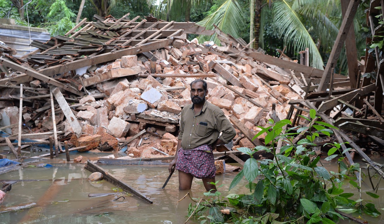 A man standing in front of the rubble of his house on the outskirts of Kozhikode district in Kerala. Photo: AFP