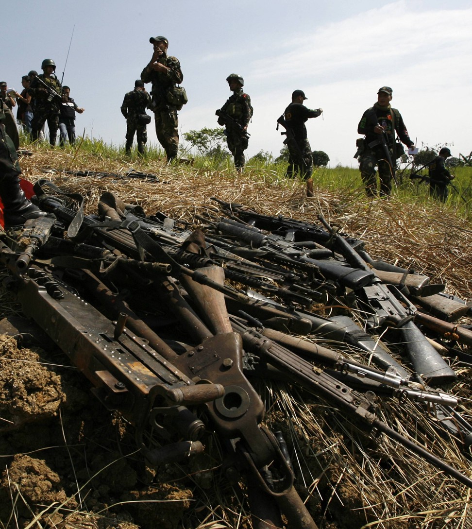 Soldiers guard assorted firearms unearthed on the farm of the Ampatuan clan following the 2009 massacre. Photo: Reuters