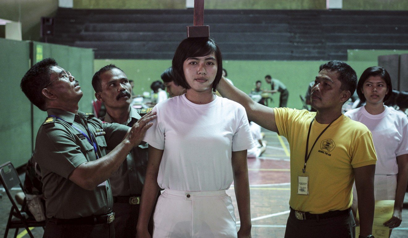 Indonesian officers measuring the height of a female candidate applying for the armed forces. Photo: AFP