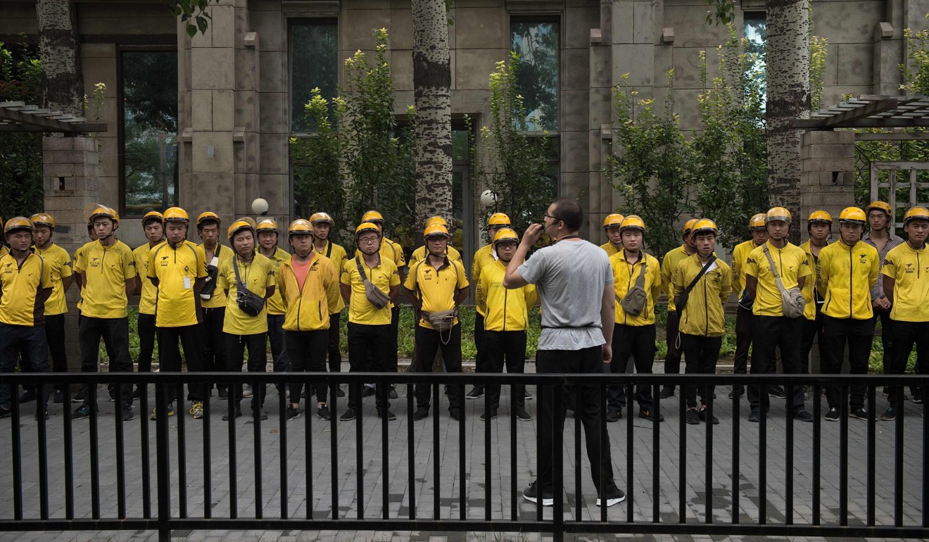 Meituan food delivery workers attend a morning briefing in Beijing. Photo: AFP