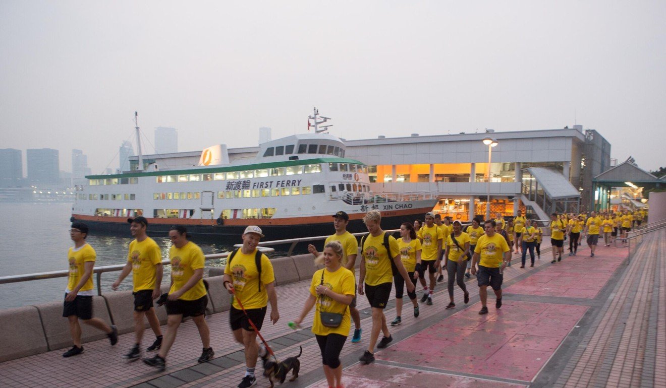 Participants stride past the ferry piers in Central as they attempt to raise money for counselling and suicide prevention services during the Darkness into Light walk in May 2017. Photo: Handout