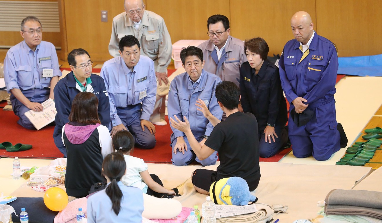 Japanese Prime Minister Shinzo Abe talks to survivors on Sunday. Photo: AFP