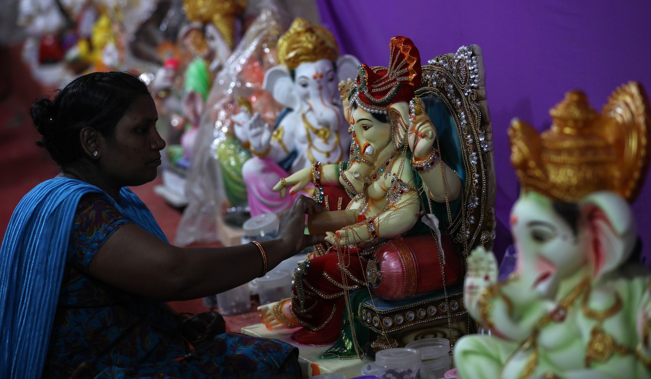 An artist works on an idol of the elephant-headed Hindu God Ganesh at a workshop in Mumbai on September 5, in time for the Ganesh Chaturti festival. The rupee fell to an all-time low last week. Photo: EPA-EFE