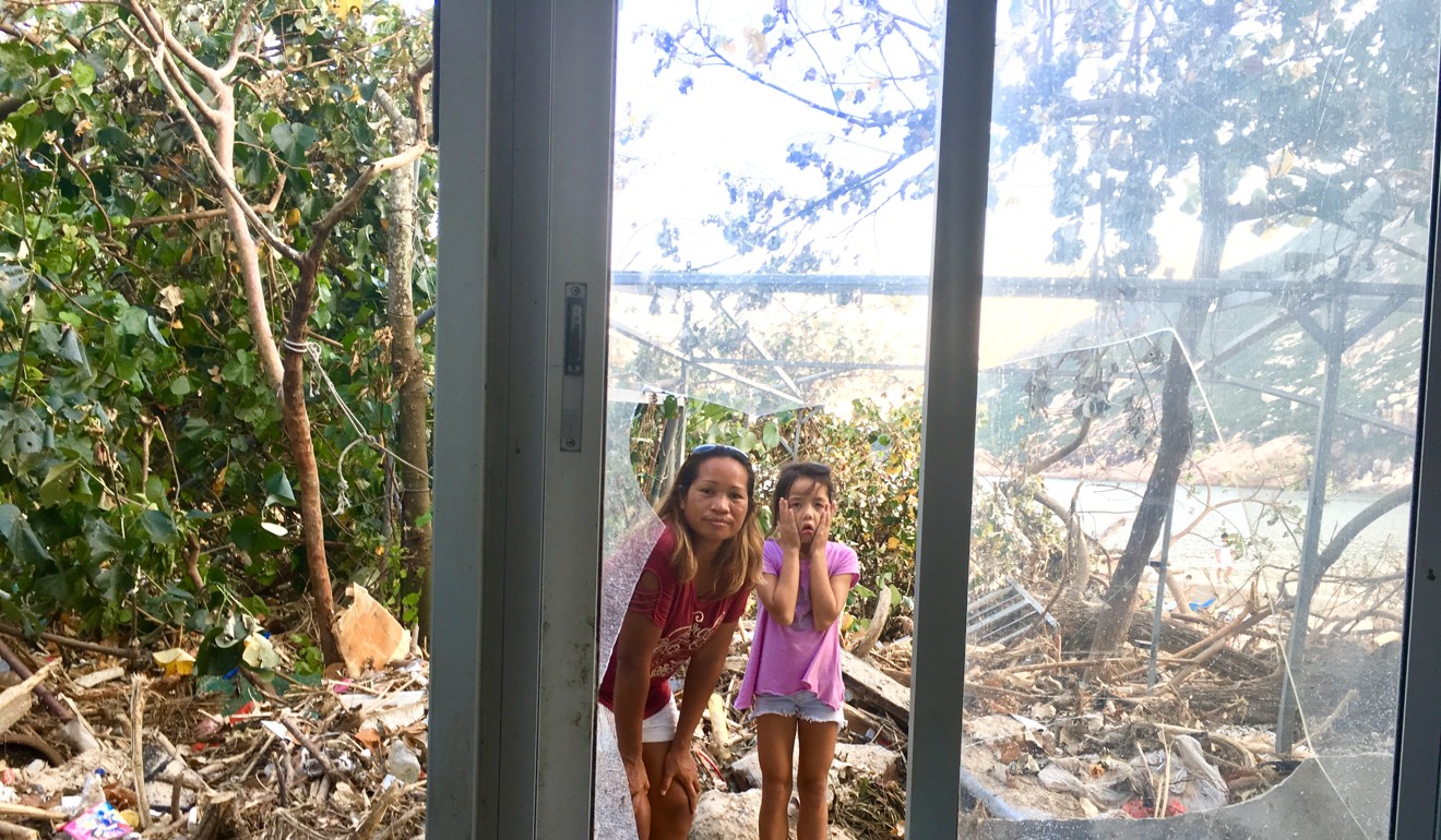 Jhena Davait and her daugher, Rhyannon, among the debris in front of their home in Shek O. Photo: Kylie Knott