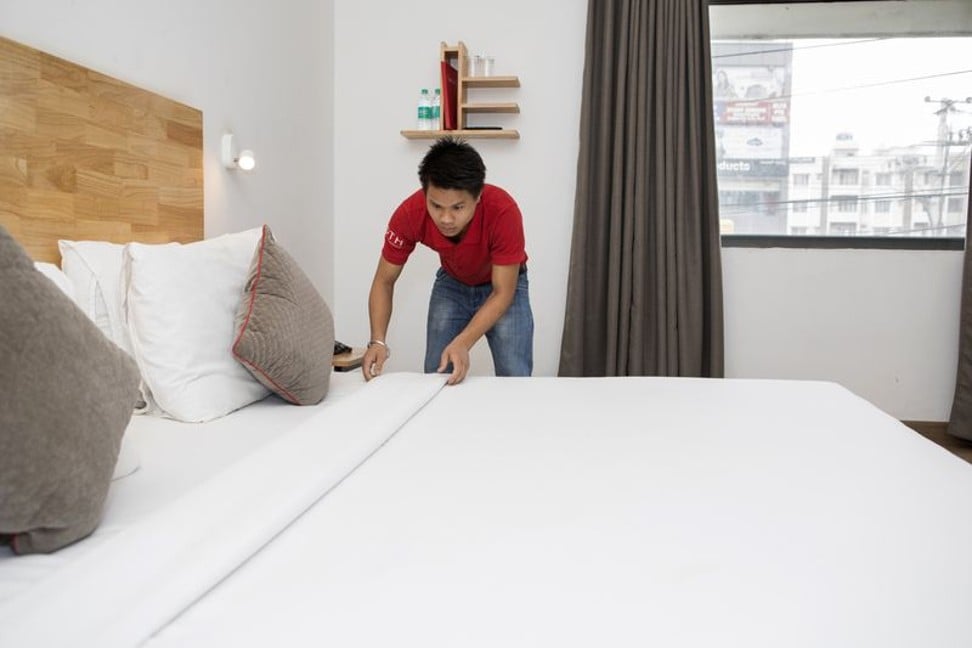 An employee makes a bed in a room at an Oyo townhouse in Bengaluru. Photo: Bloomberg