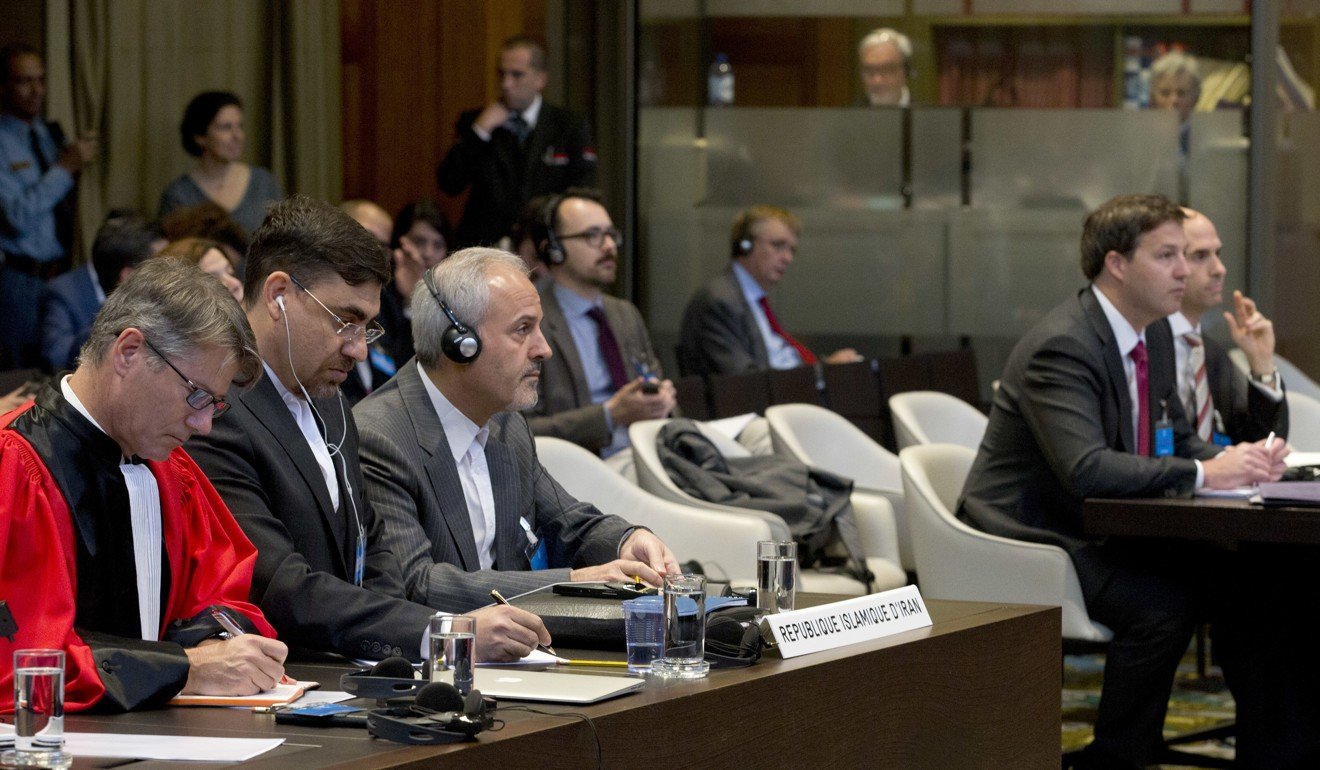 Mohammed Zahedin Labbaf (third left), agent for the Islamic Republic of Iran, and the US delegation (right) listen to the ruling of the judges at the International Court of Justice, or World Court, in The Hague, Netherlands, on October 3, 2018. Photo: AP