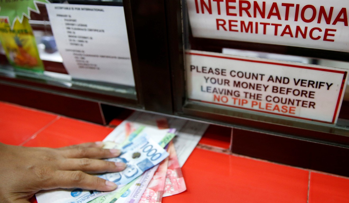 A Filipino receiving money sent by a relative working abroad at a remittance centre in Makati City. Photo: Reuters